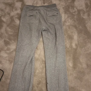 Grå mjukisbyxor från Juicy Couture - Snygga och bekväma grå mjukisbyxor från Juicy Couture i storlek XS. Enda defekten är att metallplattorna på snöret åkt av, men det märks inte