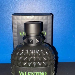 Valentino parfym - Snygg parfymflaska från Valentino med ett unikt mönster och svart lock. Flaskan har en elegant design med gröna detaljer och kommer i en matchande förpackning. Den har ca 90 ml kvar!