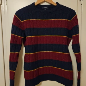 Randig tröja från GANT - Säljer en snygg randig tröja från GANT i marinblått och vinrött med gula detaljer. Tröjan är tillverkad i 80% lammull och 20% polyamid. Tröjan är M men är mindre i storleken så passar S också. Skriv om ni har frågor!