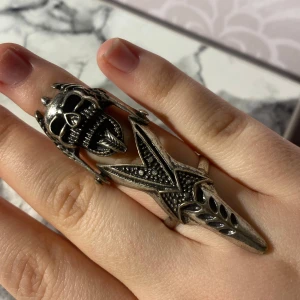 Dödskalle ring - En dödskalle ring som är unik i både utseende och passform. Den är böjbar och böjer sig med ditt finger (se bild 4). Sitter bekvämt på fingret och är justerbar så du kan göra den större eller mindre