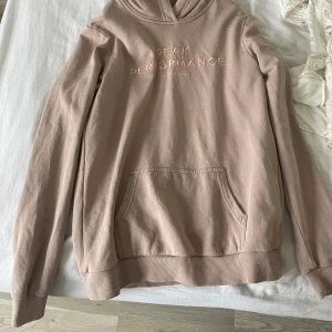  rosa hoodie från Peak Performance - Säljer en snygg rosa hoodie från Peak Performance med broderad logga på bröstet. Tröjan har en klassisk känguruficka och ribbade muddar vid ärmslut och nederkant. Pris kan diskuteras💕