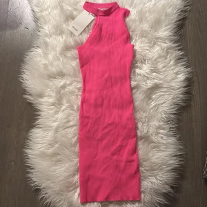 Rosa ribbad klänning från Bershka - Snygg rosa ribbad klänning från Bershka med hög krage och ärmlös design. Perfekt för en trendig look. Kort klänning❤️
