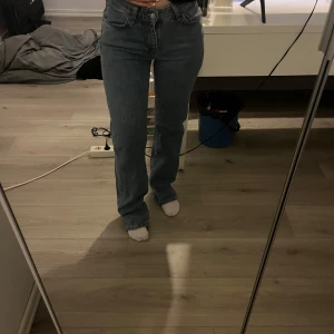 Blå jeans med rak passform - Snygga blå jeans med rak passform och klassisk design. De har en hög midja och är perfekta för en avslappnad stil. Jeansen har fem fickor och stängs med dragkedja och knapp.