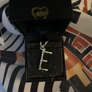 Maria Nilsdotter bokstavshalsband - Säljer mitt Maria Nilsdotter bokstavshasband med bokstaven ”E”. Inte använt så mycket så det är i mycket bra skick! Ask medföljer 🥰🥰