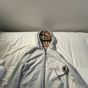 Grå huvtröja från Burberry - Hej säljer en grå burrberry hoodie i storlek L. Den är i väldigt bra skick då jag inte har använt den mycket den köptes från Burberry för ca 1 år sedan. Har du frågor så är det bara att skriva👍 pris går att diskuteras om det är realistiskt😁 