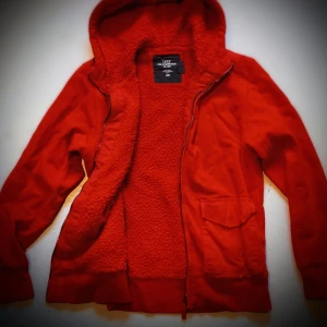Orange fleecefodrad tröja från H&M - Säljer en jätte mysig och varm orange tröja från H&M med fleecefoder och huva. Jackan har dragkedja och en praktisk ficka framtill. Perfekt för kyliga dagar när du vill hålla dig varm och bekväm.