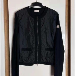 Svart jacka från Moncler - Snygg svart jacka från Moncler med dragkedja framtill och långärmad design. Storlek S!