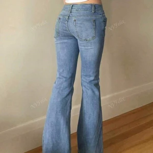 Blå bootcut jeans - Snygga blå bootcut jeans med låg midja och klassisk femficksdesign från Shien.Perfekta för en avslappnad stil med en touch av retro. Passar utmärkt till både sneakers och klackar.storlek storlek s men passr också M.
