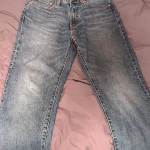 Levi's 568 jeans - Säljer ett par klassiska Levi's 568 jeans i blå denim. De har en straight passform och är perfekta för en avslappnad stil. Jeansens slitna look ger dem en cool vintagekänsla.