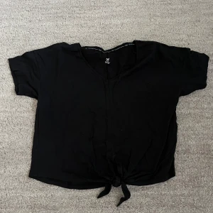 Svart knytbar topp från H&M Sport - Säljer en svart träningströja från H&M i ett mycket bra skick 
