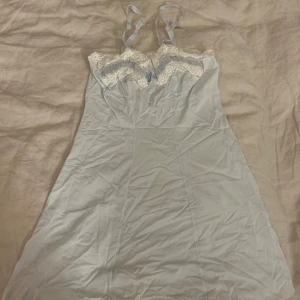 Ljusblå klänning med spetsdetaljer - Charmig ljusblå klänning med spetsdetaljer vid bysten och smala axelband. Perfekt lingerie / nattlinne eller som underklänning.