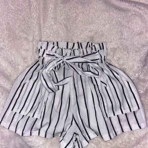 Vit randiga shorts med knyte i midjan - Dessa shorts är fina och somriga med fickor och knyte i midjan, knappt använda.