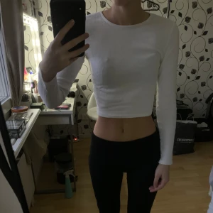 Vit ribbad croppad topp - En stilren vit ribbad croppad topp med långa ärmar. Använts ett fåtal gånger men inga tecken på användning.
