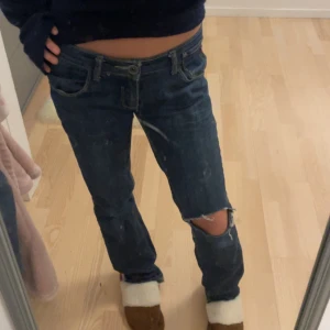 Jätte fina mörkblåa jeans med ett hål💕 - Säljer ett par los waist mörkblå jeans med slitningar på knäet. De har en låg midja och är utsvängda. Jeansen har också fina detaljer på fickorna💗💗