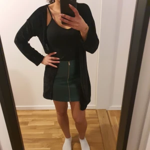 Svart Cardigan - Säljer en stilren svart cardigan med lång ärm. Perfekt att slänga över en topp för en avslappnad look. Ett måste i garderoben! Stl.S