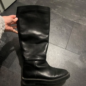 Svarta skinnstövlar Hm premium design  - Snygga svarta stövlar i skinn med en klassisk design. Perfekta för både höst och vinter. De har en robust sula och en stilren look som passar till många olika outfits.