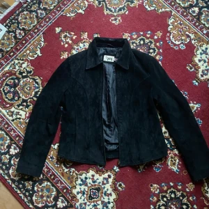 Svart mockajacka - Snygg svart mockajacka med dragkedja framtill. Jackan har en klassisk krage och långa ärmar, perfekt för höst och vår. Köpt här på Plick men var tyvärr för liten för mig :) annars jättefin!