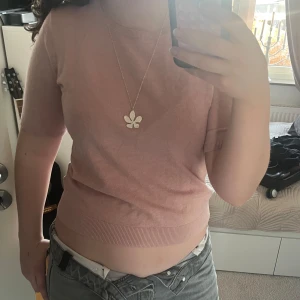 Rosa kortärmad stickad tröja - Säljer en söt rosa tröja med korta ärmar. Perfekt för vår och höst. Tröjan har en ribbad kant vid ärmslut och nederkant.