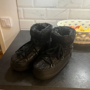 Svarta boots från Inuikii - Säljer ett par svarta unika skor från Inuikii med snörning och stickade detaljer. De har en hög krage och är perfekta för vintern. Skorna har en slittålig sula och är både stiliga och funktionella!  Storlek 38, men skulle säga att det även passar storlek 39! Pris kan diskuteras vid snabb affär, samt köparen står för frakt. 💞💞