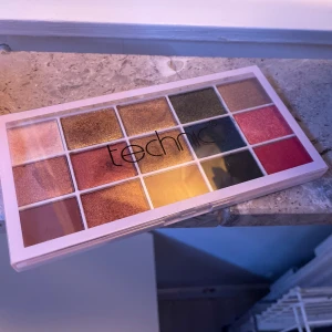 Ögonskuggspalett från Technic - Färgglad ögonskuggspalett från Technic med 15 olika nyanser. Paletten innehåller både skimrande och matta färger i guld, grön, blå, rosa och bruna toner. Perfekt för att skapa både vardagliga och festliga looks. Använd ett fåtal gånger!