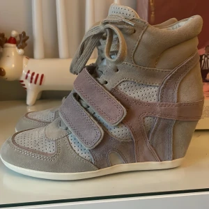 Isabel marant liknande  - Snygga beigea kilklackar från ash med kilklack och snörning. Skorna har perforerade detaljer och kardborreband för extra stil och komfort. Perfekta för en trendig look. Skorna är i mycket fint skick och är enbart använda en gång inomhus! Köpta för 189 dollar vilket motsvarar 2100kr. Passa på och köpa idag (25e) då jag ska posta idag