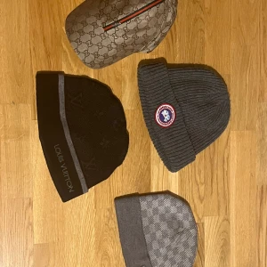 Märkes mössor + Gucci keps - Jag säljer mina Lv mössor, Canada goose mössa och Gucci keps för det är inte riktigt min stil. Skick på svarta LV mössan är 10/10, skicket på den gråa LV mössan är 10/10, skicket på canada goose mössan är 10/10 och skicket på Gucci kepsen är 8/10 då det sticker ut lite trådar på sidan av kepsen. Priset kan diskuteras men allt tillsammans skulle jag nog säga är 1700kr. Skriv vid funderingar och frågor.