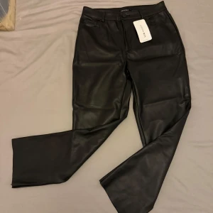 Svarta skinnbyxor - Snygga svarta skinnbyxor från Zara med hög midja och raka ben. Byxorna har fickor bak och en stilren design som passar perfekt för en trendig look.