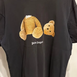 Svart t-shirt med nalletryck från Palm Angels -  svart t-shirt från Palm Angels med ett unikt nalletryck på framsidan och Palm Angels-logga på baksidan. Den svarta färgen på tröjan har blivit ljus. Storlek L men passar M