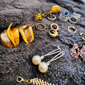 Samling av smycken i olika stilar - Säljer en samling av smycken(pilgrim med andra äkta märke) som inkluderar flera ringar, örhängen och halsband. Det finns både guld- och silverfärgade smycken, samt några med pärlor och stenar. Perfekt för att piffa upp din outfit oavsett tillfälle! allt är äkta Siler/S.steel/guldplatterat 
