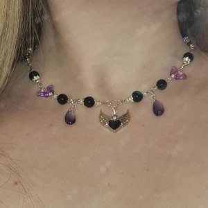 Svart och lila halsband - Glaspärlor i svart och lila. Silverdetaljer (ej äkta silver, kan innehålla nickel) 