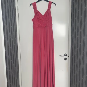 Rosa långklänning - Säljer min snygga långklänning som är oanvänd/nyskick. Klänning säljes pga köpte 2 storlekar och kunde ej lämna tillbaka den andra. Klänning är i maximodel & justerbar vid bysten för en mer figurformad byst eller mer täckt look. Nypris var 999:-