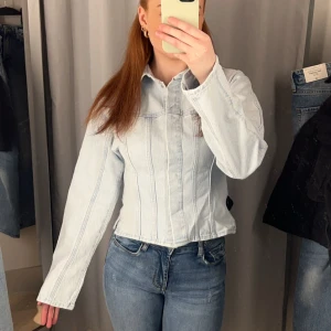 Jeans jacka/skjorta - En snygg Jeans jacka som man kan använda ute som jacka men även ha som en typ jeans skjorta inomhus. Jag skulle säga att den är lite figursydd då den är lite smalare i midjan och sen går ut där nere. Den har större armar. Aldrig använd. Storlek S