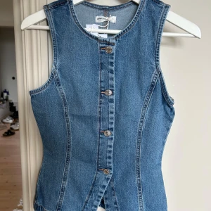 Jeansväst - Säljer den populära jeansvästen från Gina i storlek S.  Kom med bud!