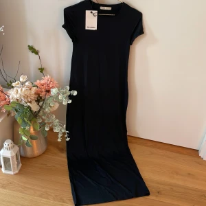 Svart Jerseyklänning figurnära - Helt oanvänd med etiketten på. Nypris:299kr. Materialet är Som Skims!  L strl men mer som M då den är figurnära. Jätte skönt material.