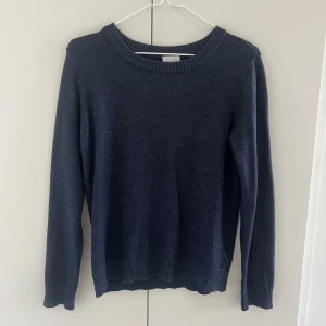 Stickad tröja - Stickad mörkblå tröja.  Ganska använd men väldigt fint skick. 
