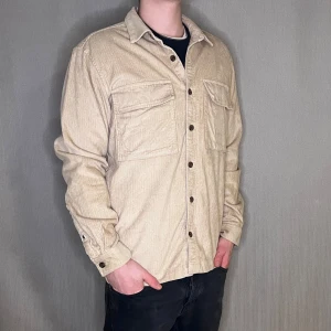 Beige manchester overshirt Storlek L  - Beige overshirt från Topman 👔✨ Material: Manchester Storlek: L Färg: Beige 🌾 Ge din outfit en stilsäker touch! Modellen på bilden är 183 cm och väger 75 kg.