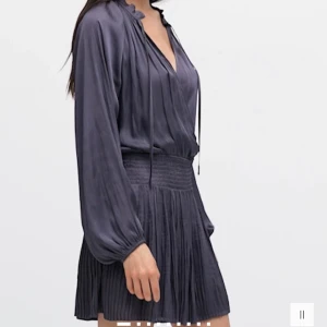 Mörkgrå omlottklänning - Snygg mörkgrå omlottklänning med långa ärmar och knytning vid halsen. Helt ny med prislapp 