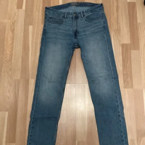 Blå jeansbyxor - Snygga blå jeansbyxor med klassisk femficksdesign och knappgylf. Perfekta för en avslappnad stil. De har en rak passform och är tillverkade i slitstarkt denim. Riktigt snygga och använda Max 3 gånger 