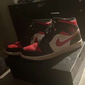 Nike Air Jordans i svart, röd och vit - !!! ÄKTA !!! Snygga Nike Air Jordans i klassisk färgkombination av svart, röd och vit. Skorna har snörning och den ikoniska Nike-loggan på sidan. Perfekta för sneaker-entusiaster. Box ingår och kvitto finns . 