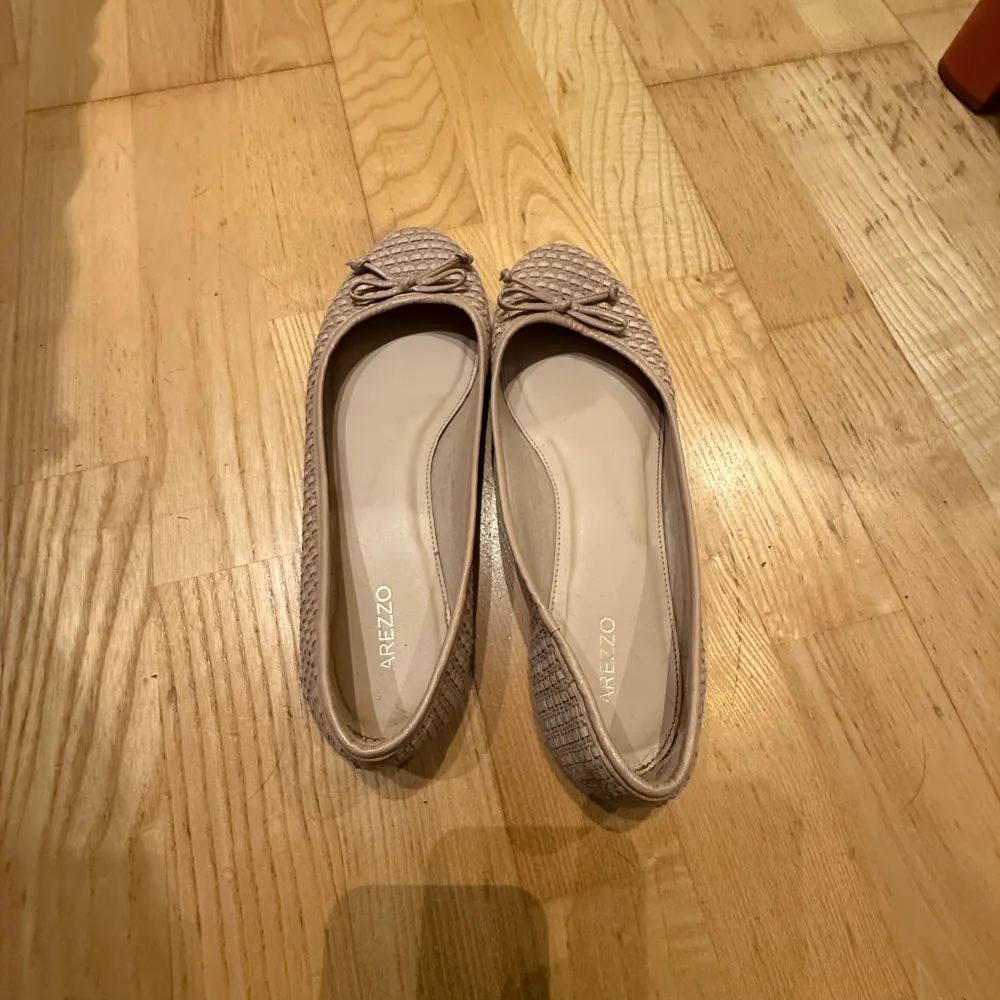 Säljer ett par eleganta beige ballerinaskor från Arezzo. Skorna har en fin rosett på ovansidan och ett diskret mönster som ger dem en unik touch. Perfekta för en stilren look. kom gärna med prisförslag🥰🥰. Kengät.