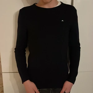 Marinblå  tröja från J.Lindeberg - Merinoull tröja från j lindeberg, storlek M, helt nyskick använt 2 gånger men sedan råkade den utför en tvätt och krymptes därmed inte passar mig. Nypris 1100kr. Den var storlek M men nu passar den s och xs