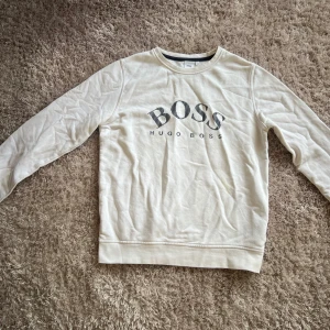Vit tröja från Hugo Boss - Säljer denna Hugo boss tröjan den är inte sönder nån stans men bara ketchup går bort med vanish fläckborttagning skick 7/10