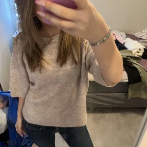 Beige stickad tröja - Säljer en mysig beige stickad tröja med trekvartsärm. Perfekt för en avslappnad stil och passar bra till jeans. Tröjan har en enkel och stilren design.