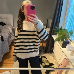 Randig stickad tröja - Säljer en mysig stickad tröja med svart och beige randigt mönster