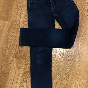 Mörkblå jeans från Levi's - Snygga mörkblå Levi's jeans i modellen 712 Slim. De har en klassisk femficksdesign och är perfekta för en stilren look. Jeansen har en slim passform och är tillverkade i ett bekvämt denimtyg.