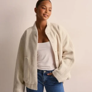 Beige teddyjacka - Mysig beige teddyjacka med knappar framtill. Jackan har en avslappnad passform och stora fickor, perfekt för kyliga dagar. Helt ny med prislapp och helt slut i hemsidan!