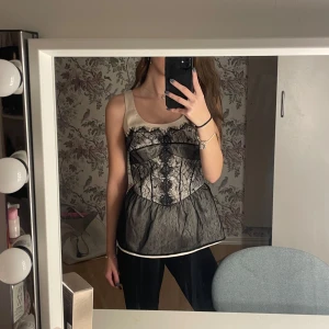 Vintage svart och beige spetslinne från Next - Säljer ett vintage svart och beige linne från Next med fina spetsdetalj köpt i Polen💕skulle säga att storleken är mellan xs-s-M☺️ 