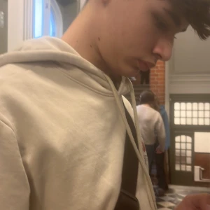 Beige hoodie - Säljer en stilren beige hoodie med justerbar huva och långa ärmar. Perfekt för en avslappnad look.