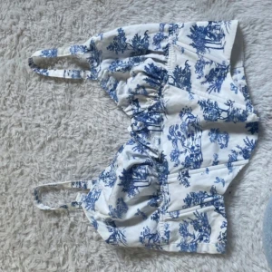 Vit och blå mönstrad topp från Bershka - Säljer en  vit och blå topp från Bershka. Perfekt till sommaren. Storlek M men passar storlek S med. 