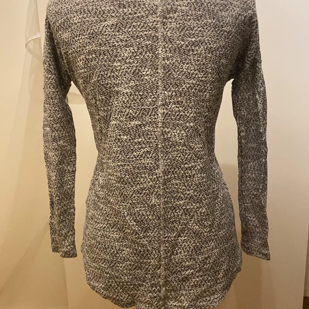 Säljer en mysig grå stickad tröja från Vero Moda. Tröjan har en rund halsringning och långa ärmar, perfekt för kyligare dagar. Den är i en melerad grå färg som ger en stilren look. Längre bak än fram. Längd: 60 cm Inga bilder när den sitter på mig! Katter finns i hemmet. Neuletakit & Villapaidat.